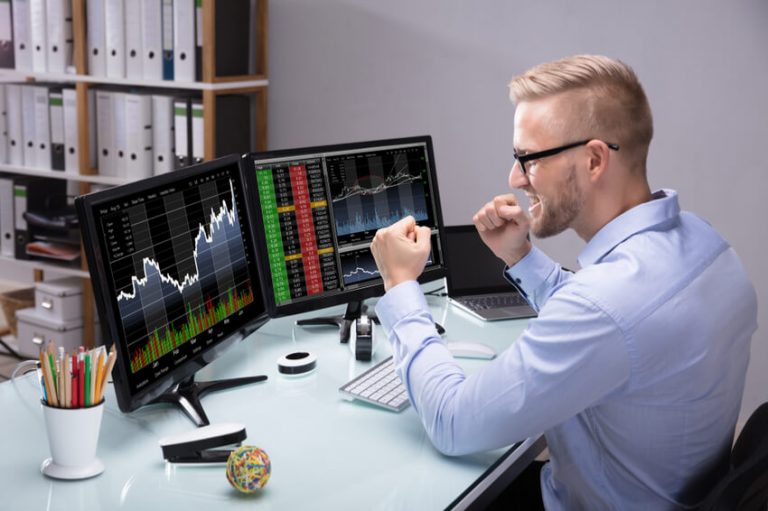 Aktien-Händler vor zwei Computerbildschirmen